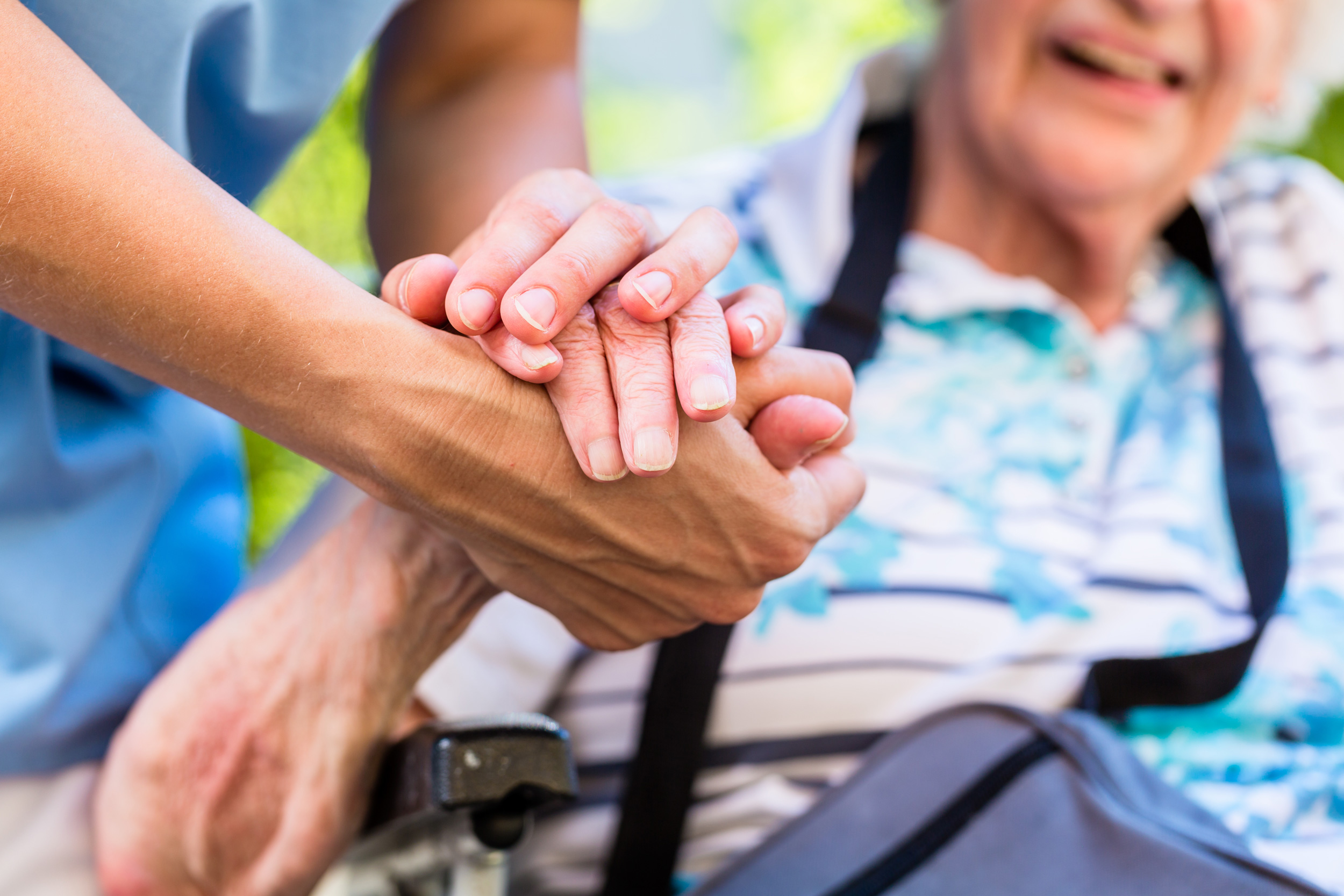 Care worker holding the hand of a person receiving support